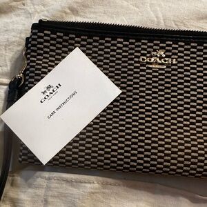 Coach wristlet with care instructions. Brand new